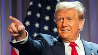 Donald Trump osoittaa oikean käden sormellaan, taustalla tähtilippu.
