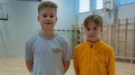 Två unga pojkar står i en gymnastiksal.