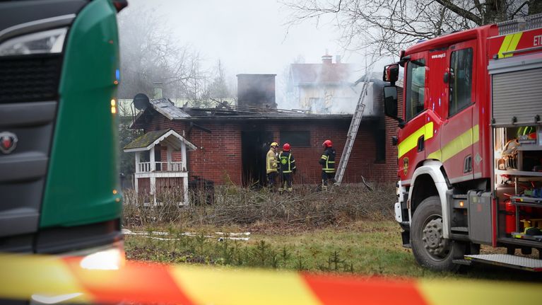 Pelastushenkilöstö tulipalopaikalla omakotitalon pihassa.