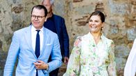 Prins Daniel och kronprinsessan Victoria går med slottsruiner i bakgrunden.