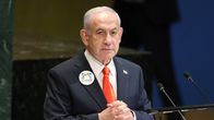 Israelin pääministeri Benjamin Netanjahu seisoo pöydän takana.