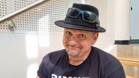 Klamydia-bändin laulaja Vesku Jokinen istuu hattu päässään portailla.