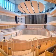 An empty, modern concert hall, with wood detailing. 