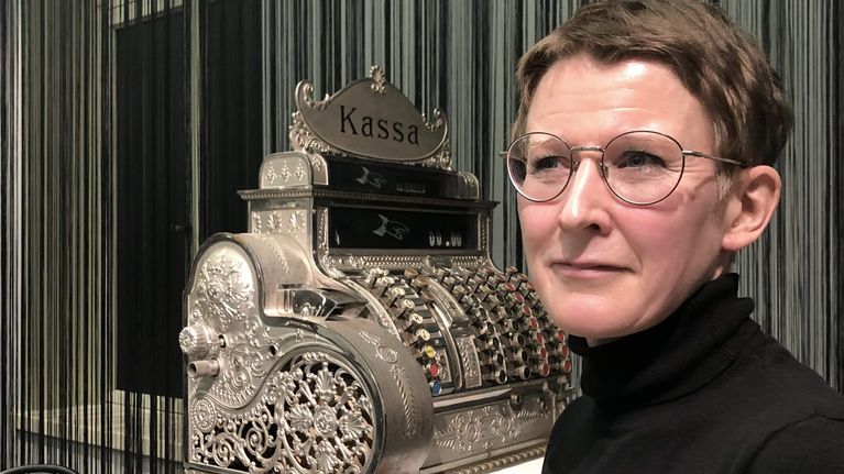 Tutkija Katri Pyysalo vanhan kassakoneen edessä
