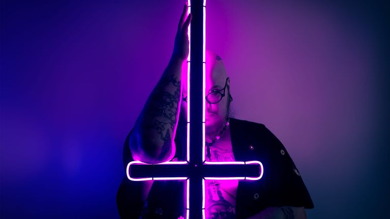 Henri Hiljander pitelee vaaleanpunaisena hohtavaa valoristiä ylösalaisin.