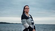 Katri Voutilainen seisoo kalliolla meren äärellä ja katsoo kameran ohi kaukaisuuteen.