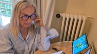A woman speaks on the phone while looking at documents.