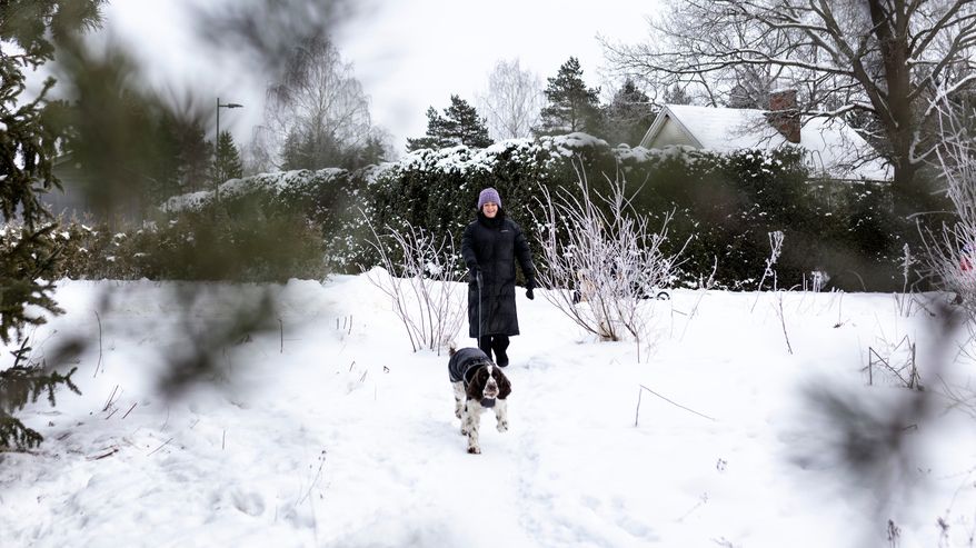 Emmi Yli-Sissala kävelee talvisessa maisemassa koiransa kanssa.
