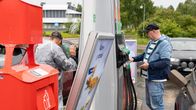 Mies maksaa bensa-automaatilla korttimaksua.