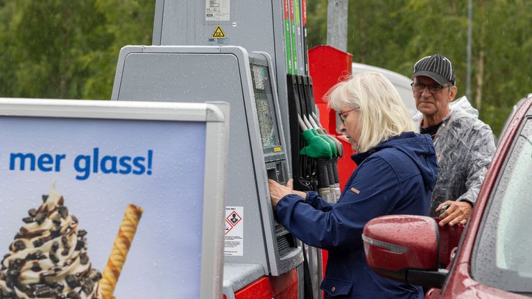 A woman paying at a self-service petrol pump.