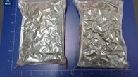 Police evidence photo of two plastic bags filled with cannabis on a blue mat.