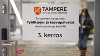 Työllisyyspalveluiden lasinen ovi, jonka takana nuori nainen.