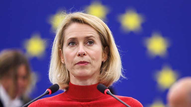 Kaja Kallas lähikuvassa punaisessa poolopaidassa, taustalla EU:n tähtikehä sinisellä pohjalla.