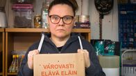 Nainen katsoo suoraan kameraan ja pitää käsissään laatikkoa missä lukee varovasti elävä eläin.
