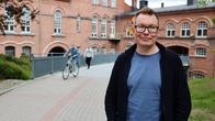 Tampereen kaupungin yhdenvertaisuuskoordinaattori Mikko Ala-Kapee hymyilee Frenckellin punatiilimiljöössä Tampereella.