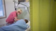Sairaanhoitaja Kirsi-Maria Parkkinen Pyhäjärven terveyskeskuksesta anonyymin saattohoitopotilaan kanssa.