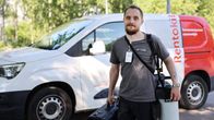 Tuholaistorjuja seisoo varusteet käsissään autonsa vieressä ja katsoo kohti.