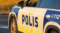 En polisbil står parkerad vid vägkanten på en landsväg.