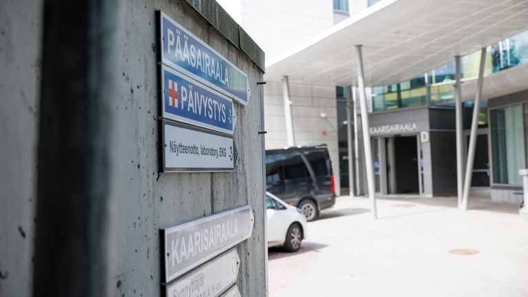 Opaskylttejä Kuopion yliopistollisen sairaalan alueella. Taustalla Kaarisairaalan ulko-ovi.