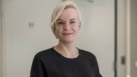 Nuori silmälasipäinen nainen mustassa paidassa.