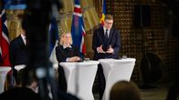 Magdalena Andersson och Antti Lindtman håller presskonferes framför flaggor.