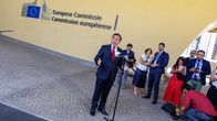 Jose Manuel Albares puhuu mikrofoniin, taustalla ihmisiä ja Euroopan komission päärakennus.