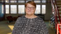Iäkäs nainen äänestyskoppien edustalla.