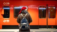 Nainen tonttulakki päässään odottaa metroa.