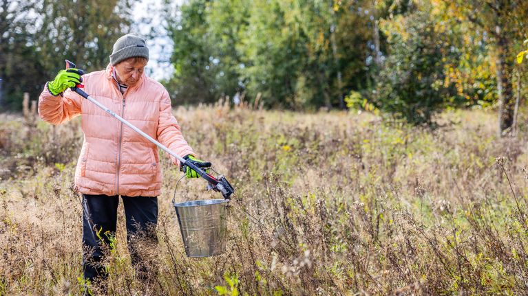 Skräpet plockar Merita Bengts upp med en gripklo och lägger det sedan i en påse eller hink. Bild: Chanette Härus / Yle