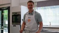 Mies kokkaa lieden äärellä.