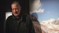 Yhdysvaltalainen Spencer Tunick seisoo valokuvien edessä Kuopion VB-valokuvakeskuksessa.