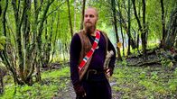 Mies seisoo metsässä. 