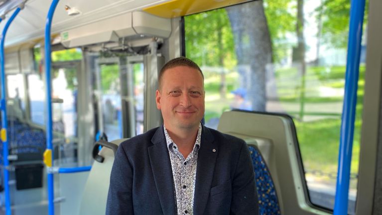 En person sitter inne i en buss. 