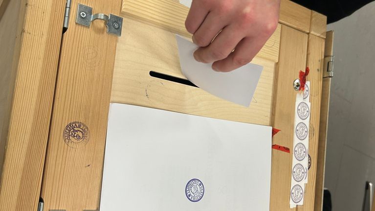 Äänilipuke tiputetaan uurnaan.