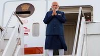 Narendra Modi seisoo lentokoneen ovella kädet liitettynä yhteen rintansa edessä.