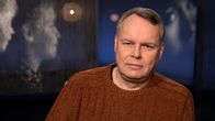 Professori Juho Saari Mediapoliksen studiossa Tampereella toimittaja Anne Flinkkilän vieraana, Juho istuu rennosti kuvassa ruskea villapaita yllään.