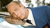 Mies (Vesa Vierikko) nojaa poskeaan auton tuulilasia vasten.