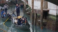 Gondoljärer styr gondoler genom en kanal i Venedig där vattennivån är betydligt lägre än normalt. På husväggarna intill ser man att vattennivån brukar vara cirka en meter högre.