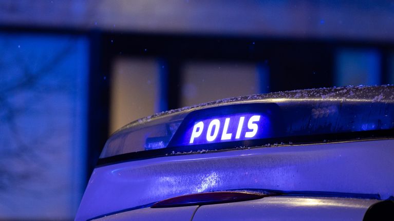 Poliisiauton vilkkuva valokyltti pimeässä yössä.