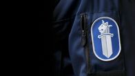 Poliisin hihamerkki olkavarressa.