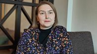 Nainen istuu pöydän ääressä. Tuuli Miettunen. 