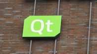 Qt Groupin logo talon tiiliseinässä.