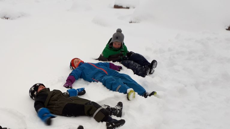 Barn leker i snön.