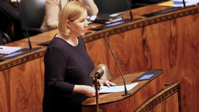 sosiaali ja terveysmiisteri Kaisa Juusoi puhuu eduskunnan suuressa salissa vanhuslaista.