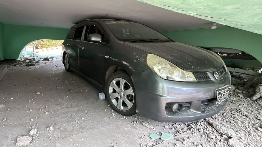 Auto on jäänyt puristuksiin romahtaneen rakennuksen alle.