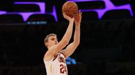 Valkoiseen Clevelandin pelipaitaan pukeutunut Lauri Markkanen heittää koripallon.