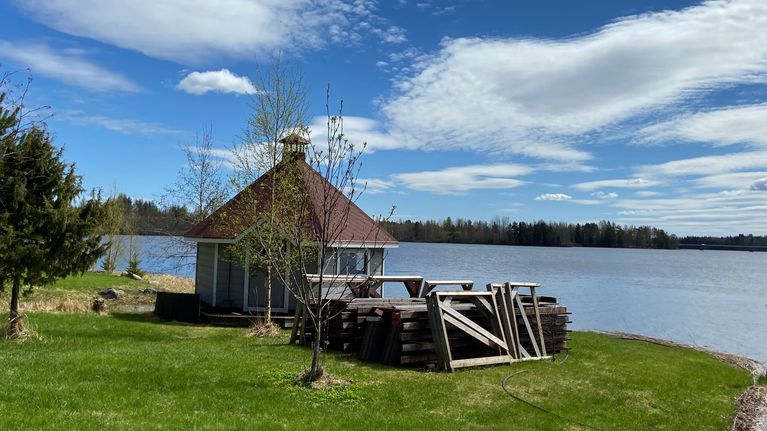 Järven rannalla huvimaja tai kota. Huvimajan vieressä on laiturin puut. Laituri on talveksi vedetty maalle ja on osina. Rantatontin puu on hiirenkorvalla. Kuva otettu toukokuun lopulla Mänttä-Vilppulassa
