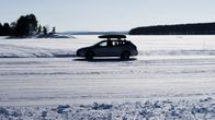 Auto ajaa jäätietä aurinkoisena pakkaspäivänä.