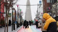 Ihmisiä kävelykadulla Reykjavikin keskustassa. Taustalla näkyy kirkko.