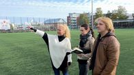 Yrittäjä Tian Zhang osoittaa kädellään kohti Rovaniemen Keskuskentän katsomoa.